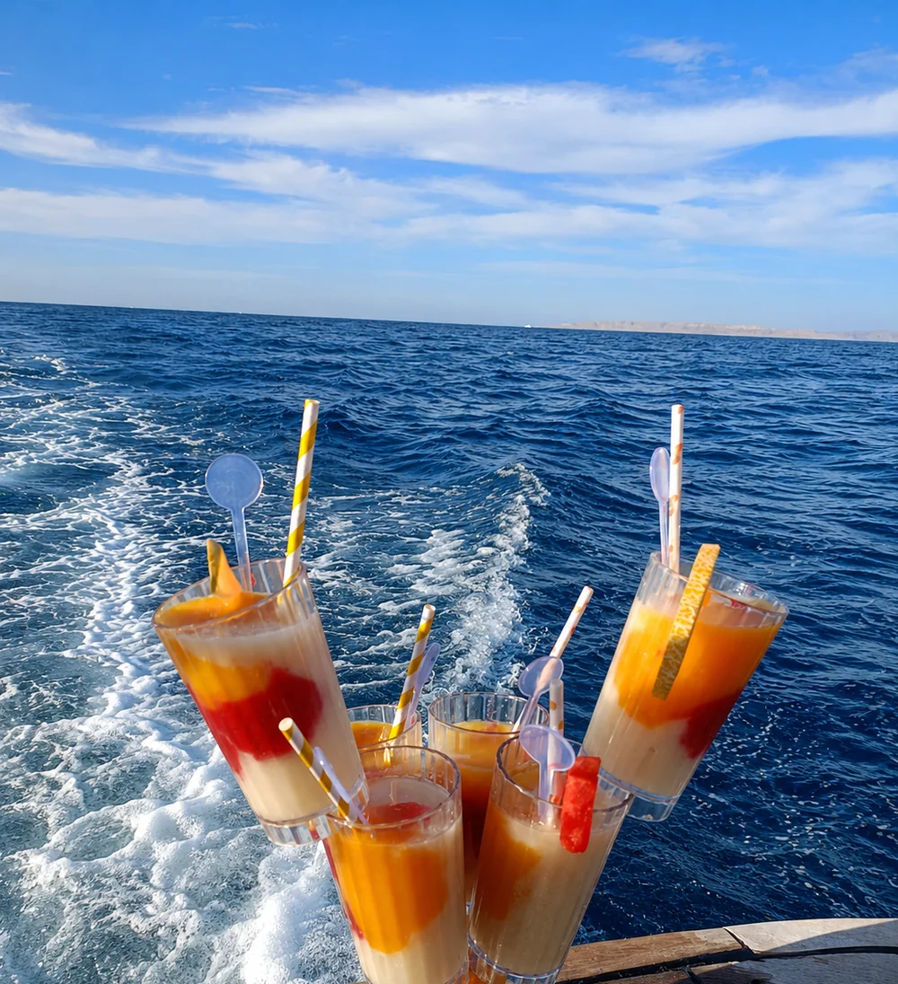 Bunte Willkommensdrinks am Heck des Schiffs mit Blick aufs offene Meer